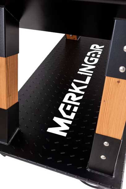 Detailansicht MERKLINGER Bodenplatte mit Logo und Holzbeinen.