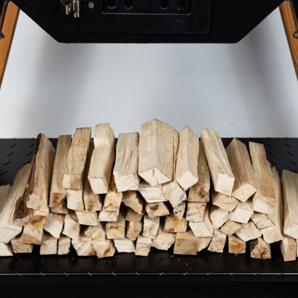 Ofenholz unter dem MERKLINGER Holzbackofen gestapelt – griffbereit zum Nachlegen.“