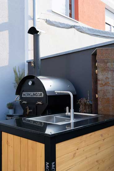 „Kompaktes Spülmodul neben MERKLINGER Ofen auf Terrasse, Granitplatte und Edelstahlarmatur