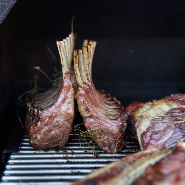 Zwei gegrillte Lammkarrees mit Knochen auf Edelstahlrost im MERKLINGER Grill.“