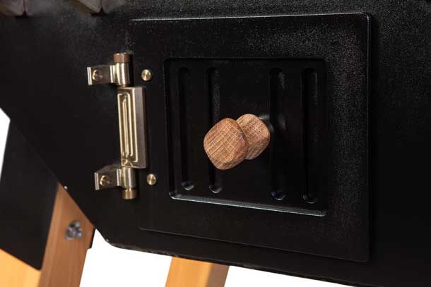 Detailaufnahme des Aschefachs und Holzgriff-Drehknaufs am MERKLINGER Rundofen.