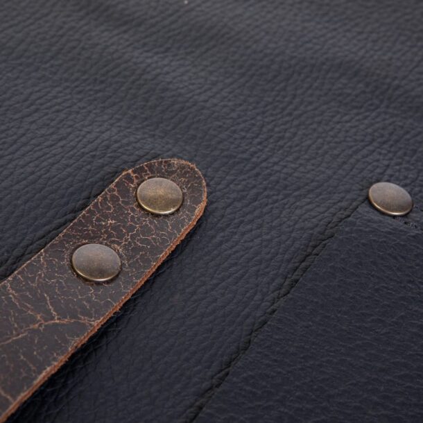 „Riemen und Messingnieten der MERKLINGER Lederschürze in Nahaufnahme – robuste Verarbeitung.“