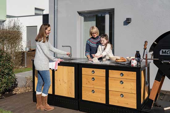 Überdachte Outdoor-Küche mit MERKLINGER Ofen; 6-Schubladen-Modul LOTTI neben Spülmodul.